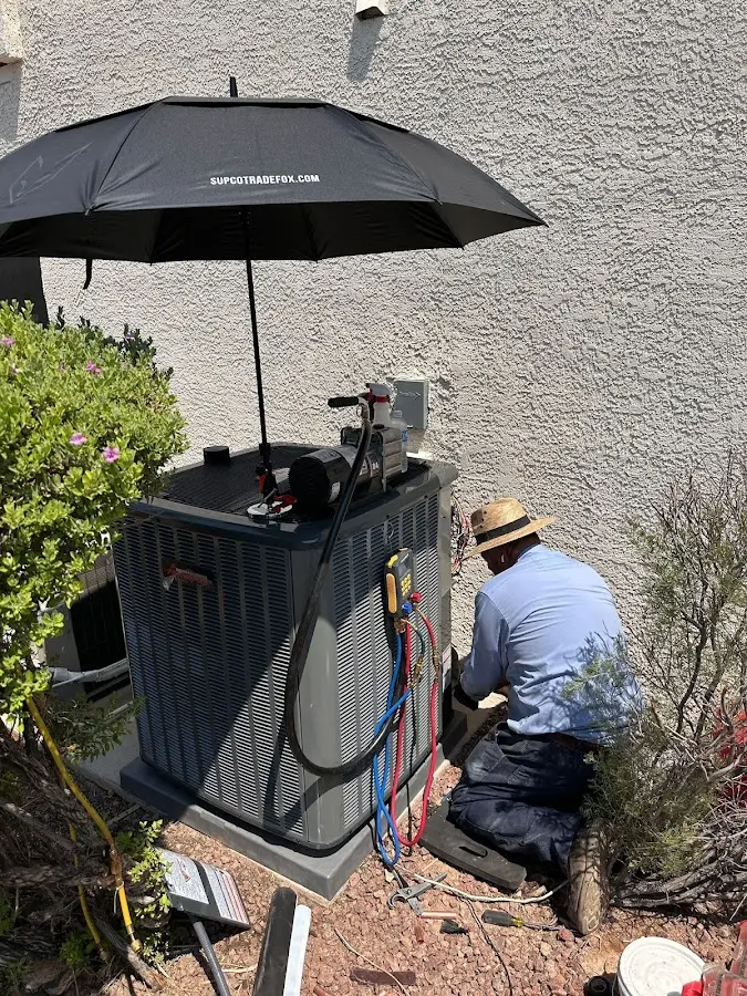 HVAC technician performing outdoor AC maintenance in Howland Center